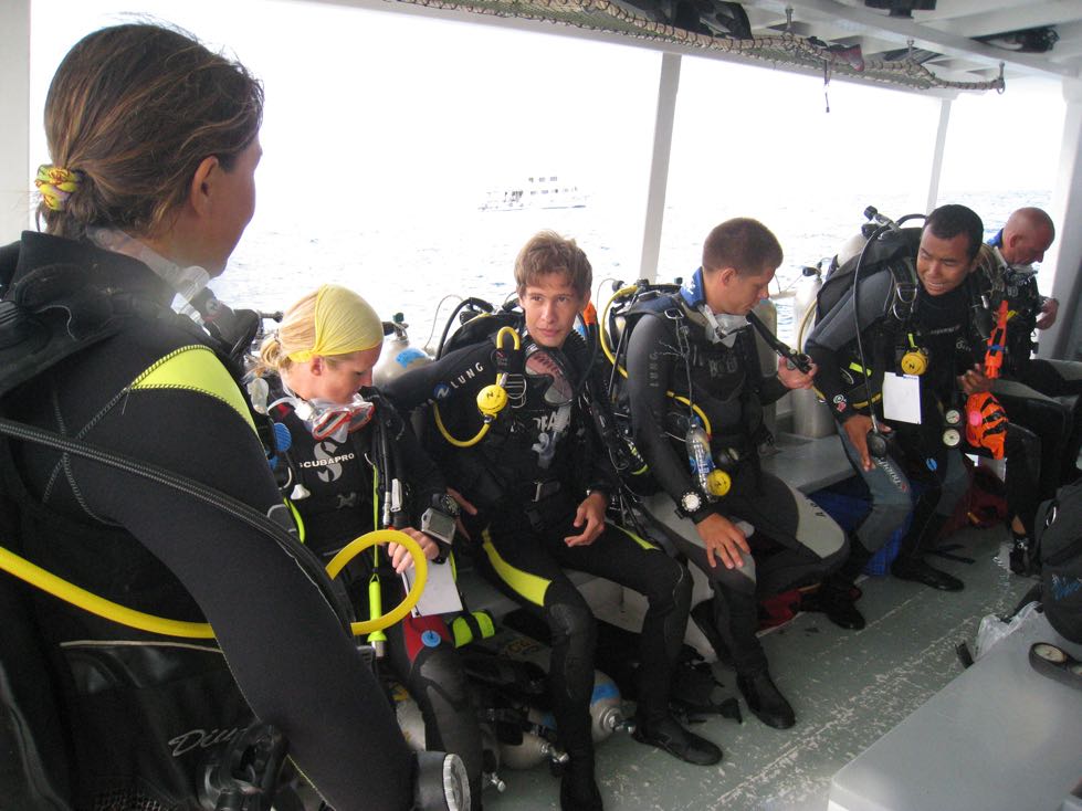 Groep ervaren duikers zit klaar om in het water te springen